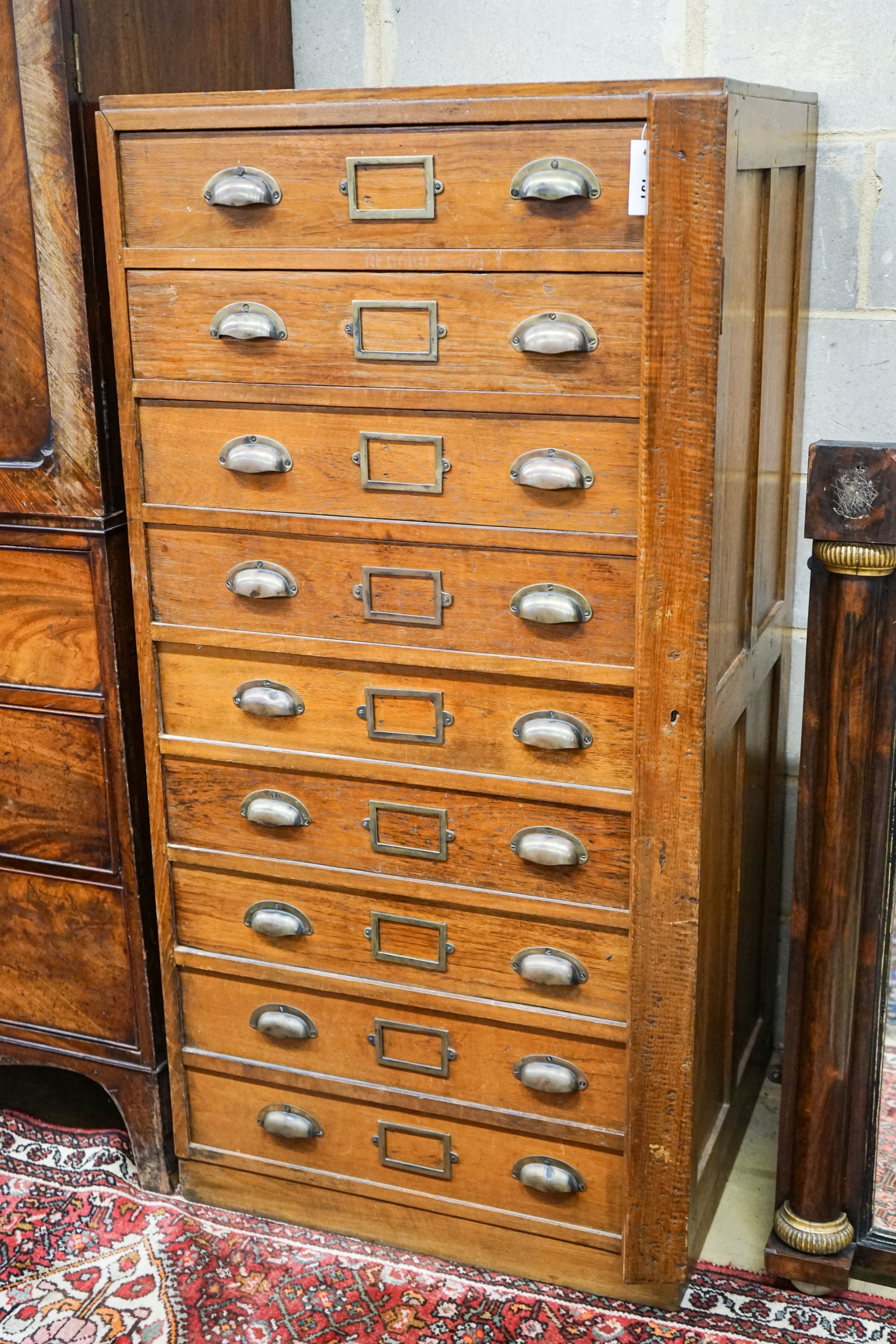 An early 20th century teak nine drawer filing chest with single locking bar, width 70cm, depth 63cm, height 142cm